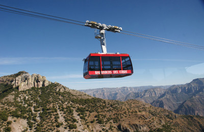 A red cable tram moving over Copper Canyon, Mexico.